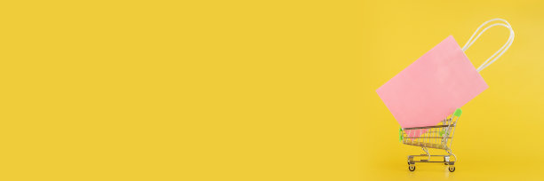 购物袋在手推车上黄色背景，礼品袋，网上购物横幅图片下载
