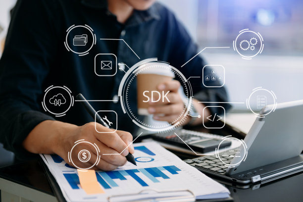 SDK软件开发工具包编程语言技术概念，人打字笔记本电脑和平板电脑与SDK图标在虚拟屏幕上。在办公室图片下载