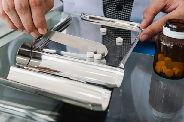 药剂师在药店按处方在合格的计数盘中配制药丸图片下载