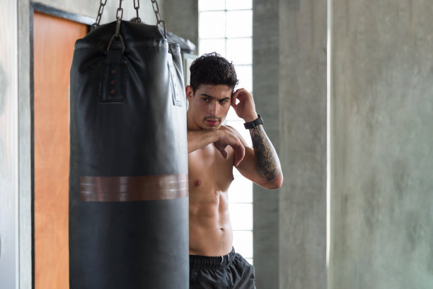 肌肉发达的年轻强壮的体育男子拳击手在健身房锻炼。年轻强壮的拳击男子在健身房锻炼图片下载