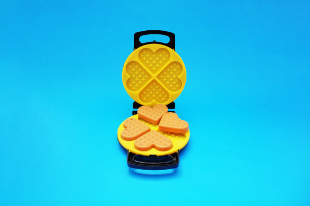 一种由塑料制成的黑色和黄色的儿童玩具华夫饼机图片下载