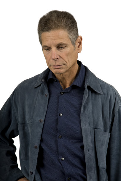 男子穿着绒面革夹克向下看，白色背景图片下载