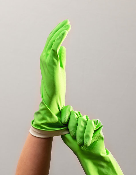 双手戴绿色橡胶手套，戴防护手套进行清洁图片下载