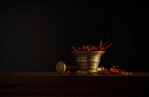 干红辣椒用金属杵和臼在黑色背景图片下载