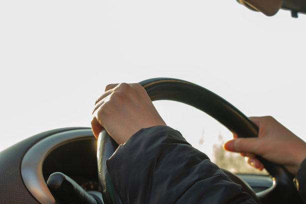 在阳光下的下午，手放在方向盘上图片下载