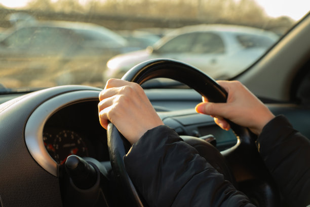 在阳光下的下午，手放在方向盘上图片下载