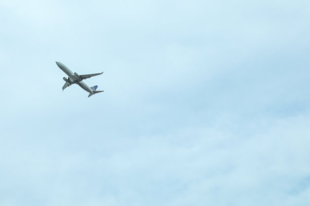 飞机在蔚蓝的天空中遨游在云和阳光中图片下载