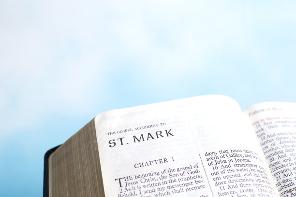 翻开的圣经到圣马可的书。以美丽柔软的天空作为背景。图片下载