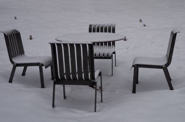 公园里被雪覆盖的金属桌椅图片下载