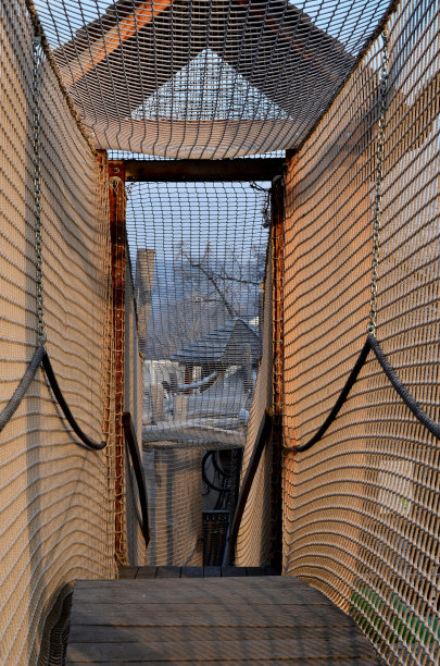 用绳子做成的网状隧道。访客的孩子，爬过迷宫。不锈钢滑轨。城市parl mebo学校庭院木制景点城堡图片下载