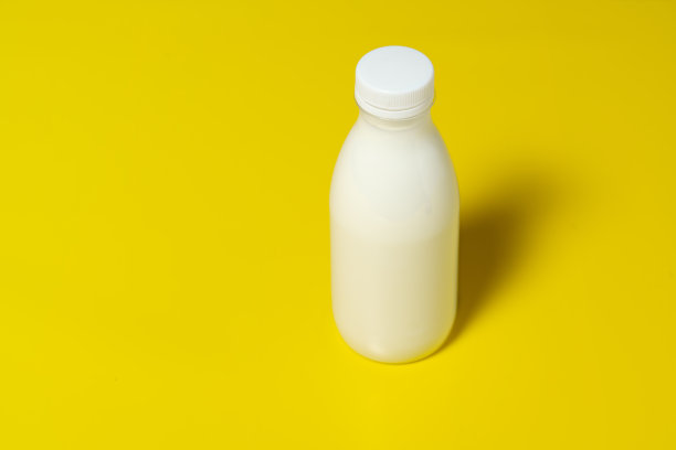 黄色背景上的牛奶瓶图片下载