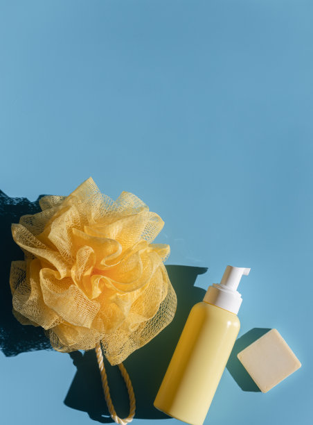 黄色的瓶子里有分配器，毛巾和蓝色的肥皂条。图片下载