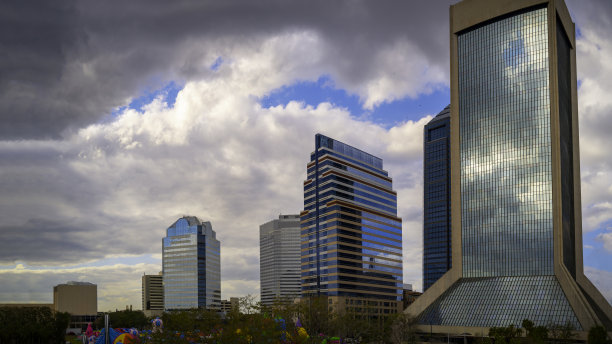充满活力的杰克逊维尔市天际线和建筑物，在美国佛罗里达州北部的滨河广场公园上有引人注目的云景，现代城市景观与家庭娱乐空间图片下载