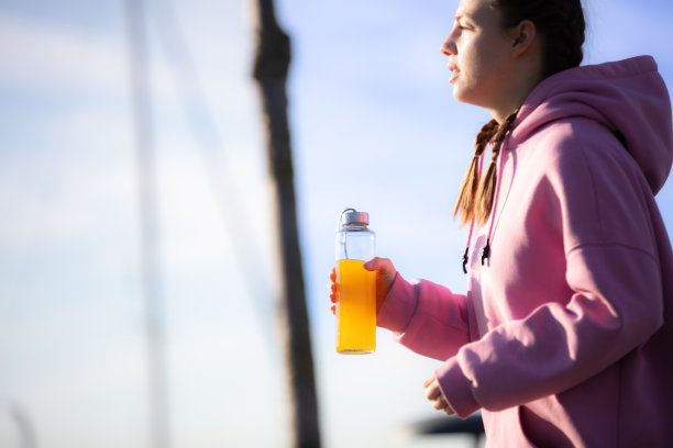 年轻女子在公园慢跑时补充水分图片下载