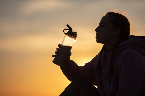 年轻的金发女子在日落时在海边进行户外锻炼图片下载