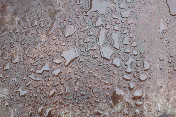 优雅的一滴:金属背景上的水滴图片下载