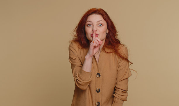 年轻女子把食指按在嘴唇上做沉默的手势表示不告诉秘密嘘安静图片下载