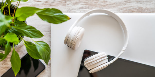 一个带有平板电脑、笔记本电脑、智能手机和耳机的办公桌的俯视图图片下载