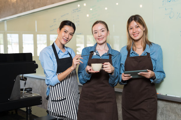 年轻的女咖啡师在咖啡店为顾客准备咖啡的肖像。一群女服务员在咖啡店服务咖啡图片下载