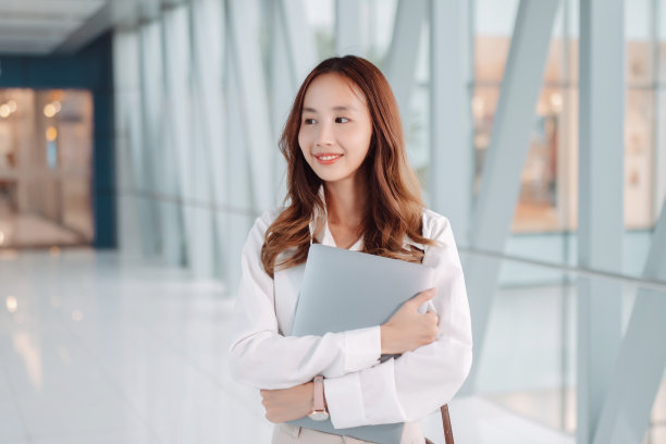 美丽的亚洲女商人使用智能手机，散步享受微笑，在办公大楼附近的现代城市通勤图片下载