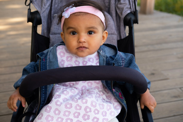 漂亮的女婴坐在婴儿车里，大声笑着图片下载