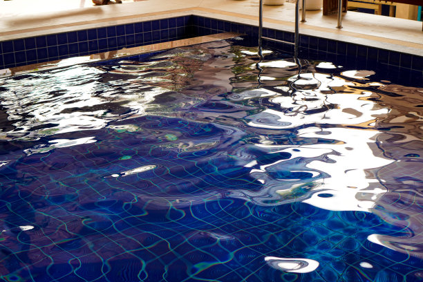 图片显示的是一个海水游泳池，清澈的蓝色背景反射着早晨的阳光。图片下载