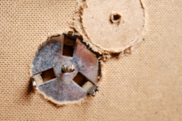 在钻头上钻圆孔的。用电动螺丝刀上带喷嘴的圆锯锯家具图片下载