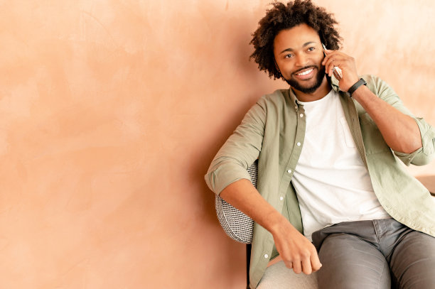 黑色快乐的人在电话上在孤立的墙背景，听对话者，自信的人享受谈话图片下载