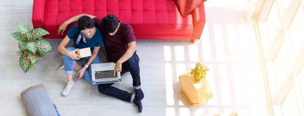 年轻的亚洲夫妇在笔记本电脑上工作网上购物的顶视图与纸箱包裹的产品在家里交付。启动在线业务概念。图片下载