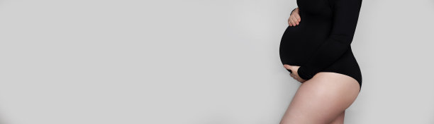 无法辨认的孕妇身体在黑色紧身衣的侧面灰色背景图片下载