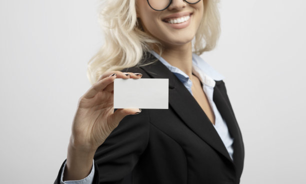 女商人展示空名片与模型设计，站在灯光背景，特写图片下载