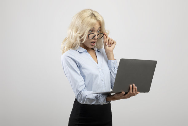 震惊的女商人看着笔记本电脑上面的眼镜有业务问题，光背景图片下载