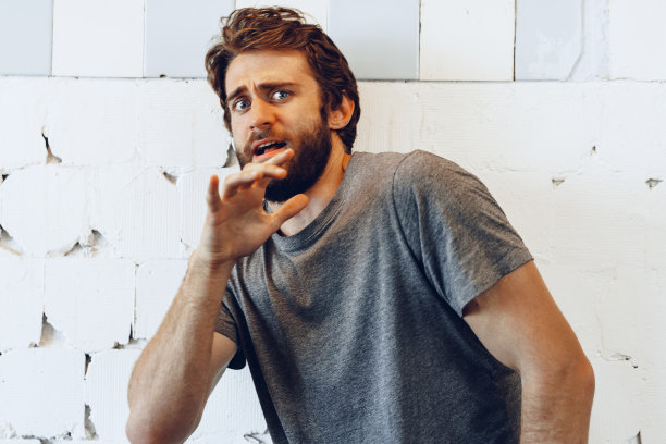 表情丰富的年轻胡须男子害怕和紧张图片下载