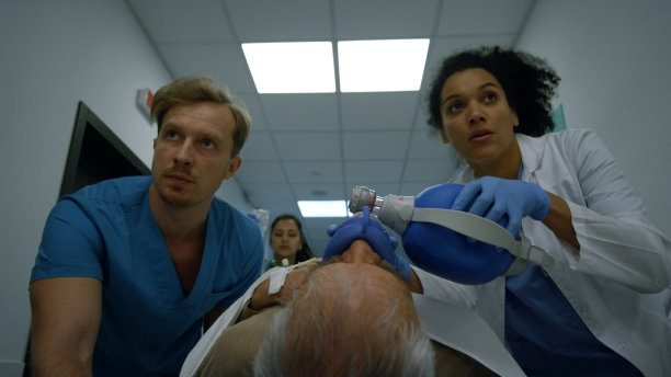 忧心忡忡的医疗小组把病人推到医院走廊的轮床上。图片下载