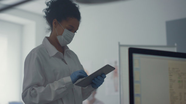 女医生站在诊所附近检查药片的分析结果图片下载