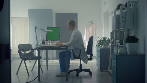 医生在诊所使用模拟电脑在线咨询。有人远程工作。图片下载