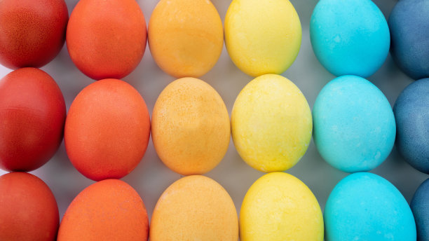 复活节彩蛋背景。鸡蛋被涂上了彩虹的相同颜色，并在白色背景上以渐变的方式摆放。快乐的复活节彩蛋在极简风格的特写照片与复制空间。图片下载