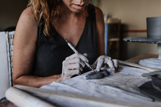 年轻的西班牙妇女在陶瓷业务和生产陶器。墨西哥和拉丁美洲的艺术小企业和企业家精神图片下载