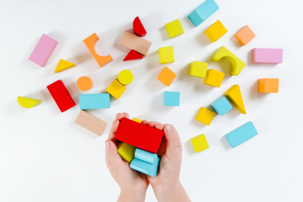 孩子的手在玩五颜六色的木砖。木制玩具。发展和学习的理念。白色背景。平的。天然材料。图片下载