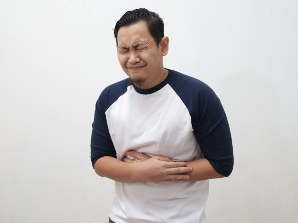 年轻的亚洲男子穿着白衬衫胃痛图片下载