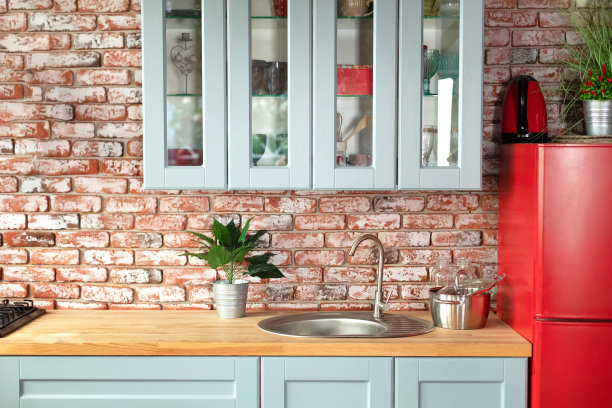 厨房有橱柜、抽屉和木制台面。室内的木制蓝色厨房立面，配有现代家具，红色冰箱，橱柜，烹饪水槽和铬水龙头，器皿。图片下载