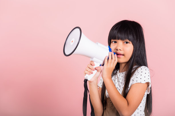 一个10岁的亚洲小孩对着扩音器大喊大叫图片下载