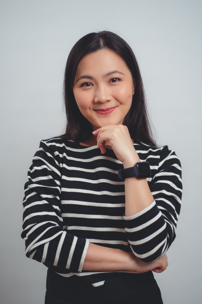 亚洲女人快乐地微笑着站在白色背景上。图片下载