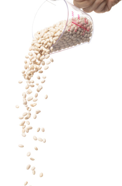 白豆从量杯里倒下来，白豆飘爆炸，抽象的云飞。白豆飞溅在空气中。白色背景隔离高速快门，定格运动图片下载