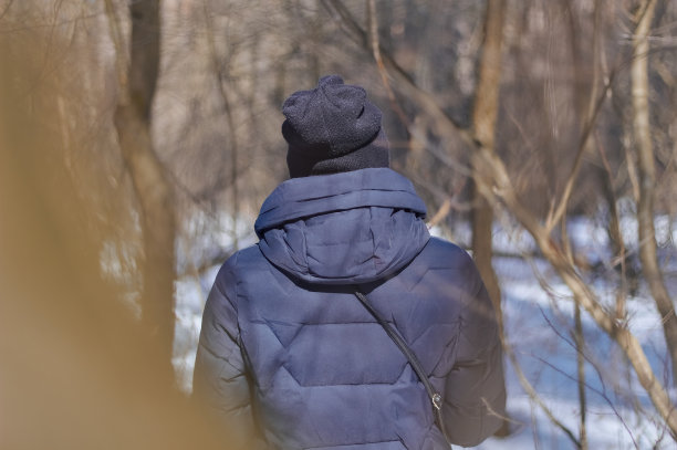 穿蓝色夹克的女孩从背后看冬天。图片下载