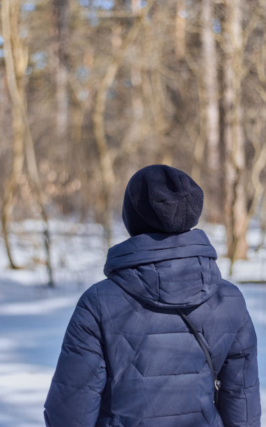 穿着蓝色羽绒服的女孩从背后看冬天图片下载