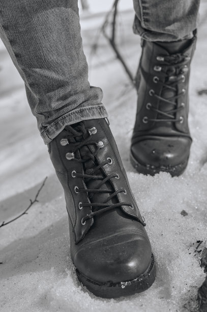 女人在雪地上穿冬靴。黑白照片。图片下载