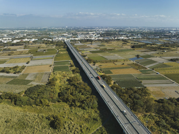 汽车在高速公路路口行驶的鸟瞰图。桥梁道路与绿色花园和树木相连接的建筑概念。图片下载