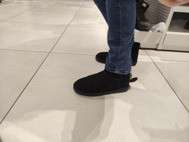 一名男子在一家商店试穿黑色冬季靴图片下载