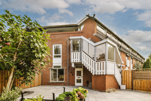 一栋有白色阳台的红砖房子图片下载